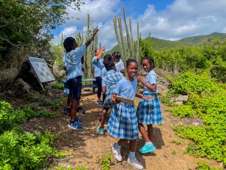 Students participate in a nature scavenger hunt during a school visit.