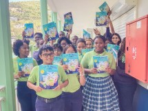 Students at St. Dominic High School with books they received from the Island of Discovery project.